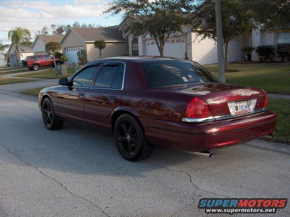 Maroon 2004 Ford Crown Victoria parked on street, red SUV in background