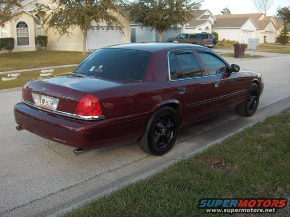 Maroon Ford Crown Victoria parked on street, rear view. License plate says 'PATRK'