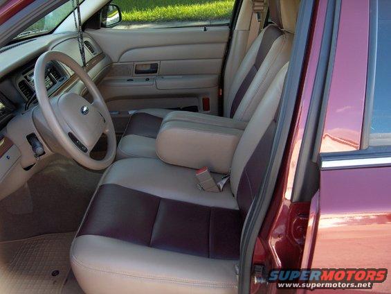 Interior of a maroon car with tan and dark red seats. Steering wheel and dashboard visible