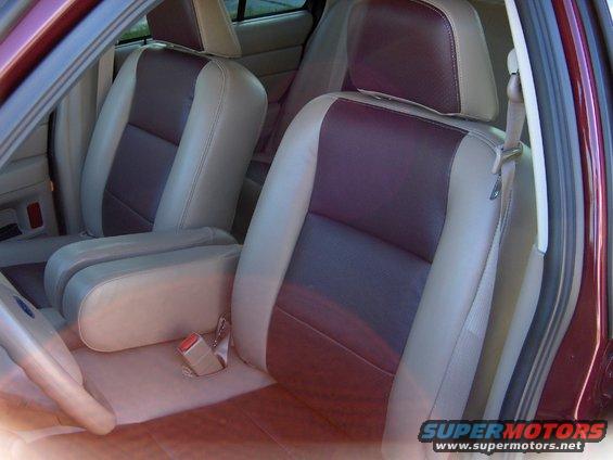 Car interior with two-tone tan and dark red seats, tan armrest, and seatbelt