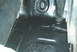 1986 Ford Bronco - Close-up of a vehicle's interior floor, showing areas of rust and recent black paint application.