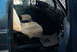 1986 Ford Bronco - Interior of a blue truck, possibly from the 1980s, showing seat covers and a floor mat.
