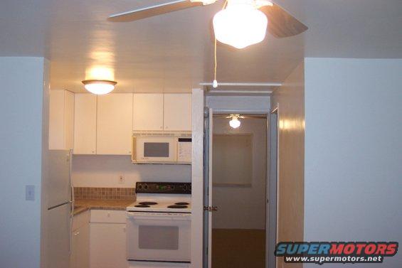 Kitchen with white cabinets, microwave, oven, and refrigerator