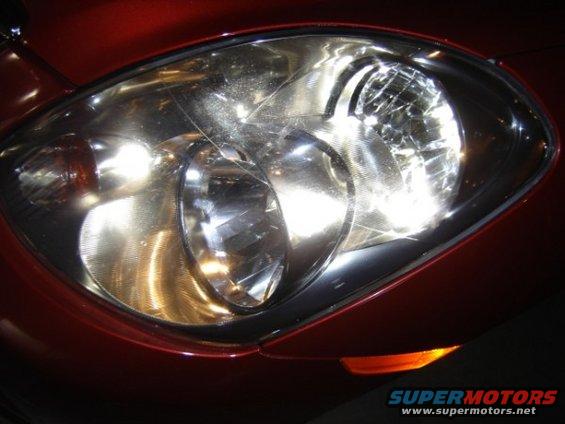 close-up of a car's headlight assembly, showing the clear lens and internal reflectors