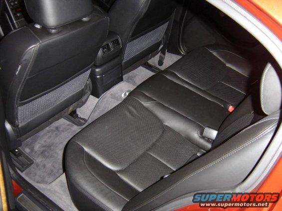 Rear leather seats and carpeted floor of a car interior