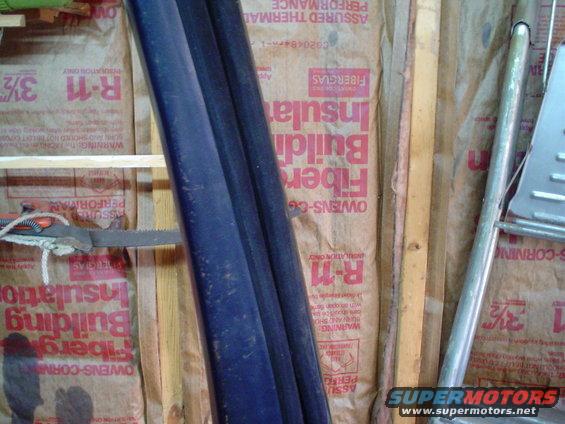 Building insulation with R-11 and Owens Corning Fiberglas branding, along with dark blue pipes and a metal ladder