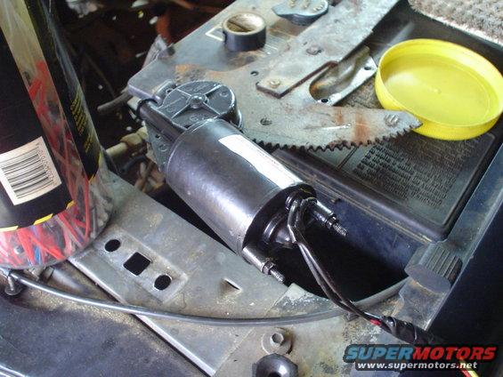 window motor assembly with wires connected, next to a battery and yellow cap