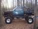 1995 Toyota Tacoma - This heavily modified pickup truck features oversized off-road tires, a custom roll cage, and a flatbed conversion.