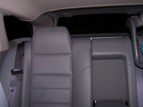 Rear seats of a car with gray leather upholstery and a seatbelt