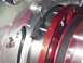 1990 Ford Mustang - Detail of an engine's pulley system, showing machined metal and red anodized parts.