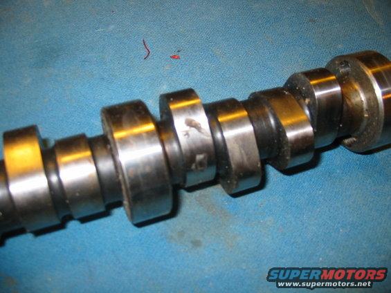 Camshaft with multiple lobes on a blue surface