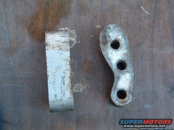 two metal bracket pieces, one with three holes, on a wooden surface