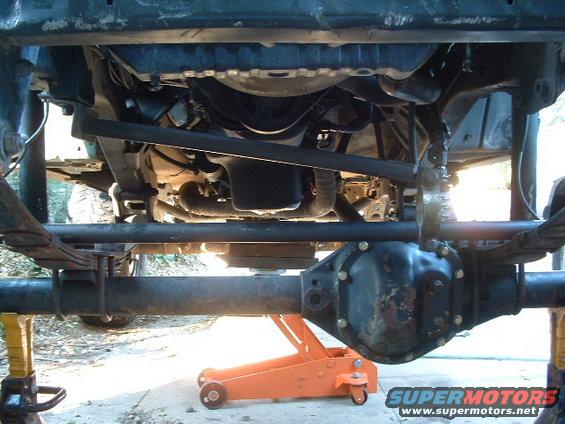 1994 Jeep YJ front axle, leaf springs, and steering linkage supported by jack stands and a floor jack