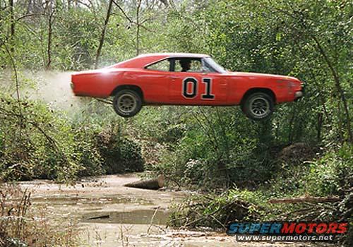 Red 1969 Dodge Charger flying over a creek, number 01 on door, dust trail