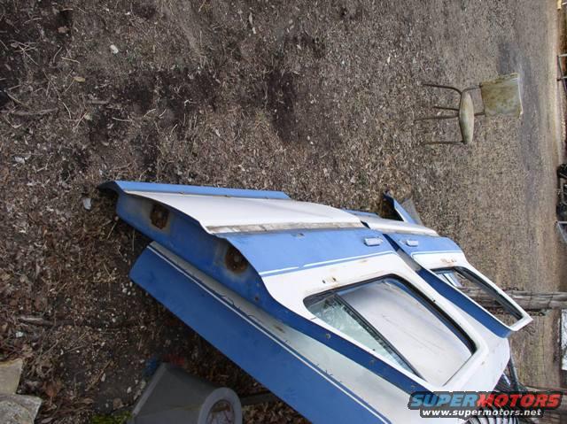 blue and white vehicle doors and body panels lying on the ground