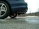 1995 Ford Probe - Close-up of the rear wheel and bumper of a vehicle on a wet, partially frozen road.