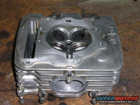Engine cylinder head with two valves visible, part of SuperMotors.net
