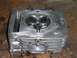 1900 Honda Big Red - Close-up of an engine cylinder head, showing internal components and part of the SuperMotors.net logo.