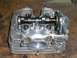 1900 Honda Big Red - Close-up of a disassembled motorcycle engine cylinder head, showing internal components.