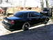 2001 Ford Crown Victoria - A black 2001 Ford Crown Victoria sedan is parked outdoors next to a black Jeep.