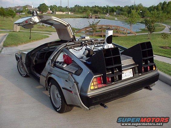DeLorean DMC-12 with gull-wing doors open, rear view showing flux capacitor components