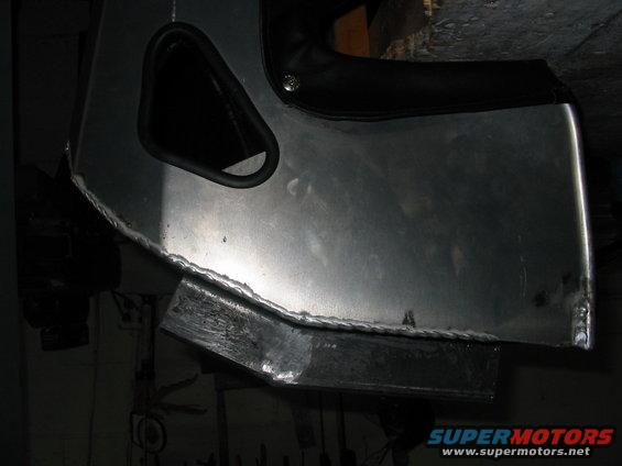 Close-up of custom aluminum fabrication with visible welds and a black trim piece