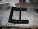 1985 Ford Crown Victoria LTD - A black metal bracket sits on a workbench, possibly a custom part or repair component.