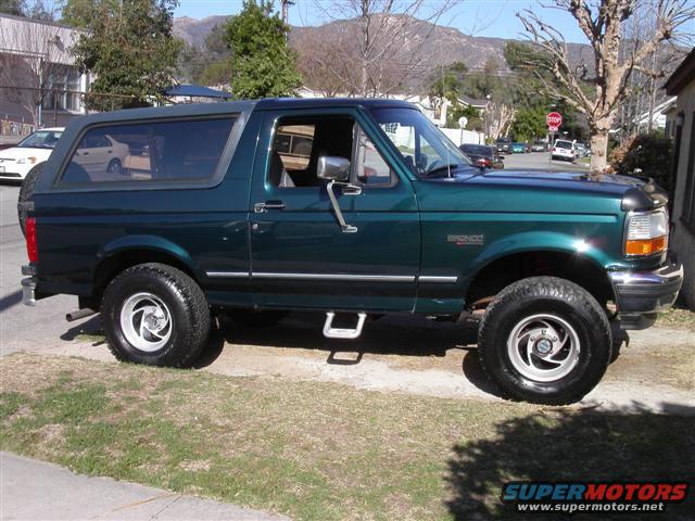 Green 1995 Ford Bronco parked on a residential street