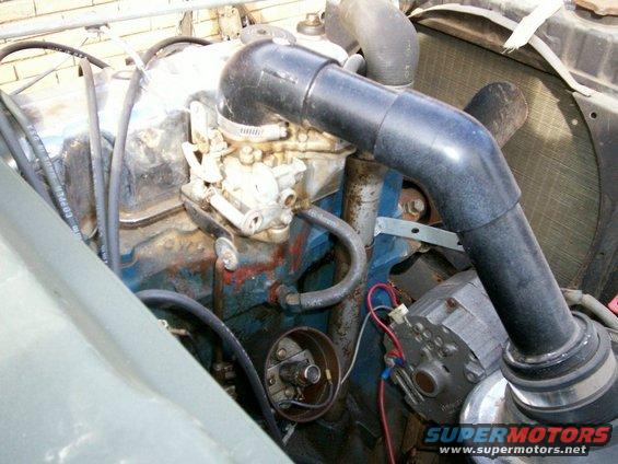 Angle shot of CJ2A 64 Ford Falcon Holley carb and open top of distributor