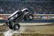 1976 Ford F-150 - A monster truck performs a jump during a Monster Jam event, kicking up dirt.