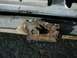 1966 Ford F-250 - Rusted metal bracket with a bolt, likely a vehicle part.