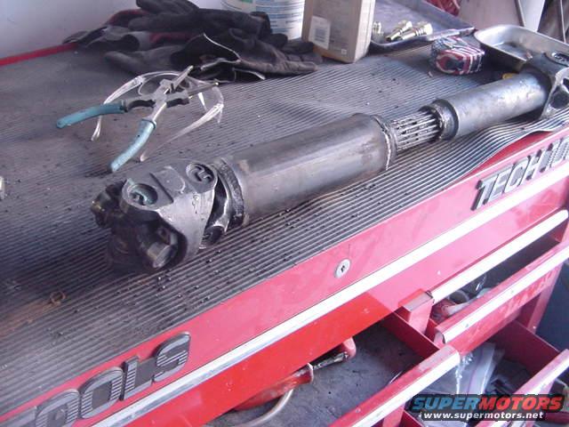 Driveshaft with U-joints and splined end resting on a red toolbox