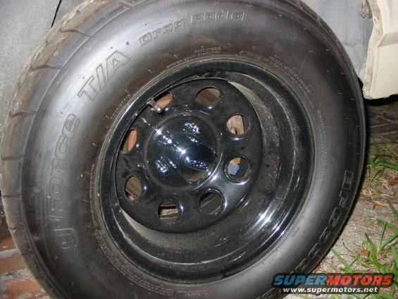 T/A Drag Radial tire on a black rim with multiple lug holes