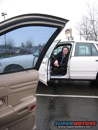 1999 Ford Crown Victoria, white sedan with open driver's door, person inside