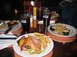 1999 Ford Crown Victoria - A table is set with various meals and beverages, including burgers, fries, steak, and drinks.