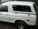1978 Ford Bronco - This 1978 Ford Bronco, viewed from the side, has a white camper shell and a dented fuel door area.