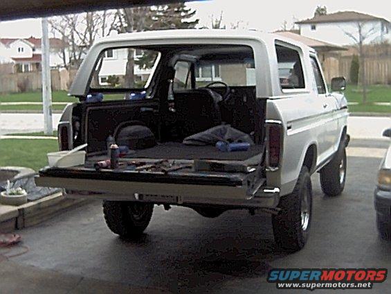 White 1978 Ford Bronco with tailgate down, showing interior and tools