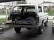1978 Ford Bronco - Rear view of a white 1978 Ford Bronco with its tailgate open, revealing tools and cargo area.