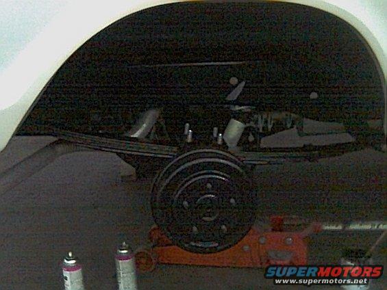1978 Ford Bronco rear axle with leaf springs and drum brake assembly, supported by an orange jack