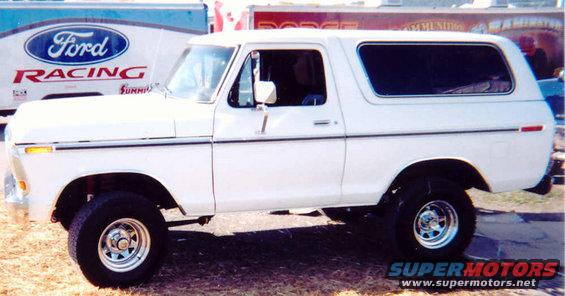 White 1978 Ford Bronco, side view, chrome wheels, lifted suspension, dark tinted windows