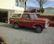1978 Ford Bronco - Red 1978 Ford Bronco with white top parked outside a house and garage.