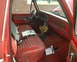 1978 Ford Bronco - The interior of a 1978 Ford Bronco shows red striped seats, wood grain dashboard accents, and a small potted plant.