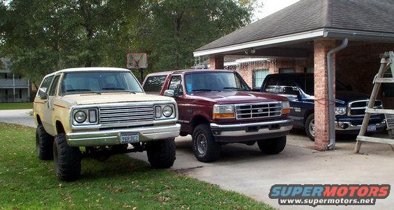 1978 Dodge Power Ram lifted with large tires, parked next to a maroon Ford Bronco and a dark blue Dodge Ram pickup