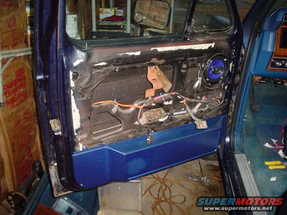 Door panel removed showing wiring and speaker. Blue door panel visible