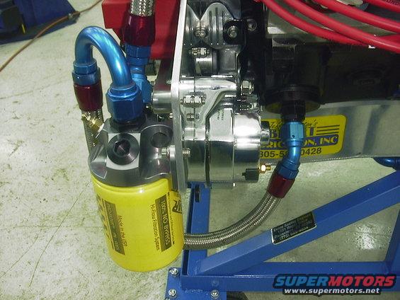 Yellow oil filter with blue hoses and chrome alternator