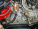 1986 Ford Mustang - Close-up view of an engine's carburetor and fuel filter assembly.