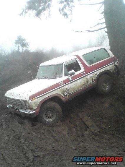 White and red 1978 Ford Bronco stuck in mud