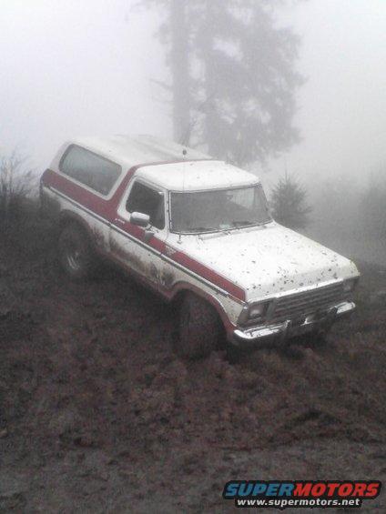 1978 Ford Bronco stuck in mud with red stripe, front passenger side visible