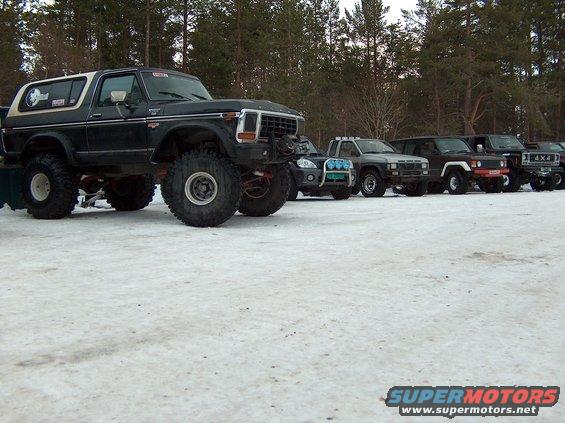 Black 1979 Ford Bronco with lifted suspension and large tires, parked in snow