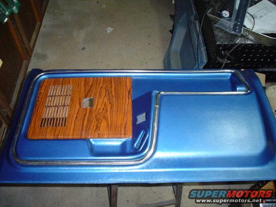 Blue door panel with wood grain insert and chrome trim